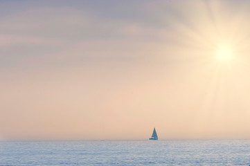 Obraz na płótnie Canvas sailboat on the horizon in a summer sunset