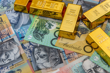 Golden bullion at australian dollar banknotes close up