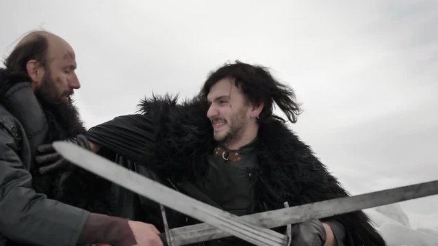 Close up of two vikings fighting with swords