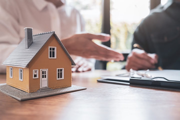 Fototapeta premium Car and House model with agent and customer discussing for contract to buy, get insurance or loan real estate or property background.