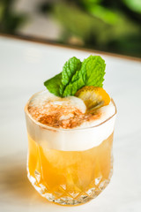 Cocktail with orange bitter and orange peel and mint leave