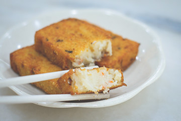 three pieces of deep fried carrot cake with real carrot bits inside