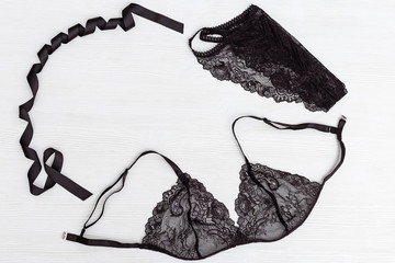 Beautiful lace Black lingerie set on white wood background with copy space. Top view Womens...