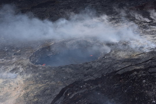 Arial View Of Mauna Loa Volcano Crater Hawaii Smoke Billowing From The Crater And Fissures As Magma Leaks To The Surface