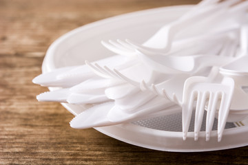 Disposable plastic crockery on wooden background