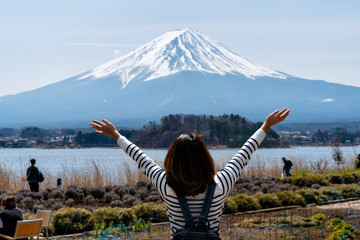 Young woman traveler looking view of mount fuji from lake kawaguchi side with happinest, Mt Fuji beautiful view from the lake kawaguchiko near Tokyo in Japan