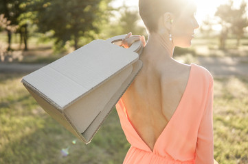  Woman holding paper kraft bag, outdoor shot in the street
