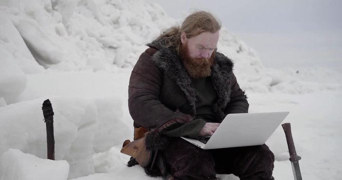 Portrait of bearded viking using laptop computer