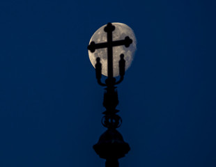 Fototapeta na wymiar Silhouette on the top of a church with the moon in the background