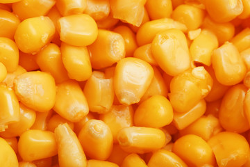 Golden canned corn, as distributed on a plane background and texture of popcorn. Before watching a movie top view. Close-up