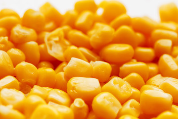 Golden canned corn, as distributed on a plane background and texture of popcorn. Before watching a movie top view. Close-up