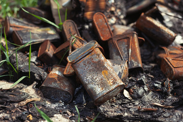 Burnt old rusty cans thrown away in the forest