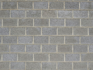 Gray brick wall of a fence folded from large stones background