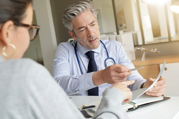 Fototapeta premium Doctor going through results with patient in clinic office