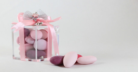 Background for baby girl baptism with pink sugared almonds