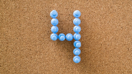 four, number made by pastel blue pushpin on cork board texture, top view