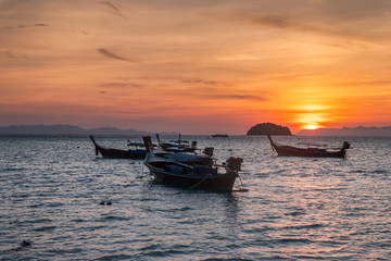 Fototapeta na wymiar Wooden long-tail boats on tropical sea at sunrise morning