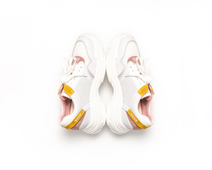 White female sneakers on white background. Fashion blog or magazine concept. Women's shoes, trendy sneakers, fashion, style, lifestyle. Flat lay top view copy space minimal background.