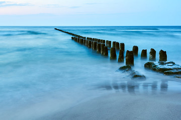 Wooden breakwater on the Baltic coast in the evening in Poland.