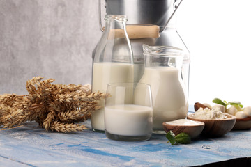 milk products. tasty healthy dairy products on a table. sour cream in a white bowl, cottage cheese bowl, cream in a a bank and milk jar, glass bottle and in a glass
