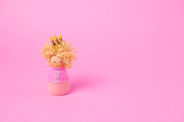 Princess wooden doll on pink background. minimal concept. copy space.