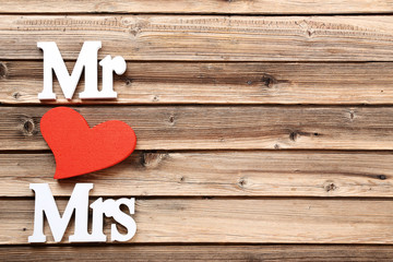 White letters Mr and Mrs with red heart on brown wooden table