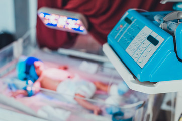 A keyboard on an infant warmer and a baby in it at the blurred background. Concept of children medical treatment. Medical equipment