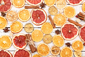 Dried citrus fruits with cinnamon, star anise and sugar cubes on white wooden table