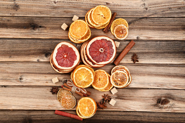 Dried citrus fruits with cinnamon, star anise and sugar cubes on brown wooden table