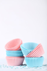 Colorful cupcake cases with sprinkles on white background