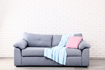 Soft pillow and plaid on grey sofa