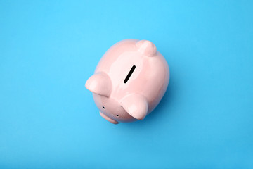 Pink piggy bank on blue background