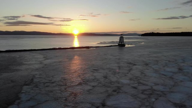 Drone approaching the lighthouse across the icy lake found in Burlington, Vermont.