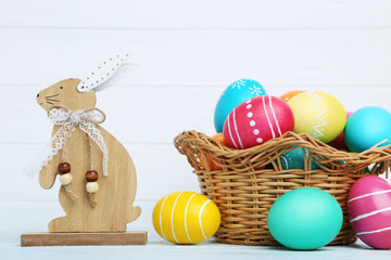 Colorful easter eggs with wooden rabbit on white background