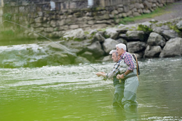 Fly fishing expert guiding novice in river