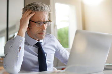 Fototapeta premium Businessman wearing glasses working in contemporary office