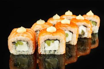 Philadelphia roll sushi with salmon, avocado, cream cheese on black background for menu. Japanese food