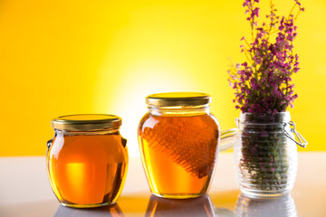Sweet honey in the comb, glass jar on wooden background