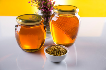 Sweet honey in the comb, glass jar on wooden background