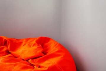 Top of orange beanbag in room corner.