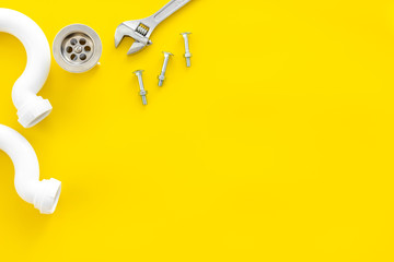 Plumber profession with gear and instruments for repair tubes on yellow background top view copyspace