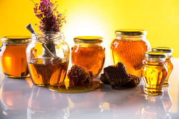 Honey in jar with honey dipper on wooden background