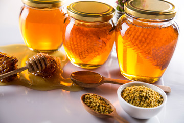 Honey in jar with honey dipper on wooden background