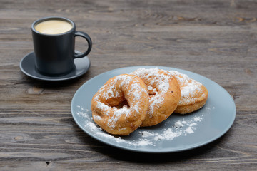 sweet donuts in sugar and coffee