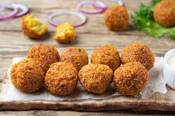 Vegetarian dish - falafel balls from spiced chickpeas on wooden rustic table.