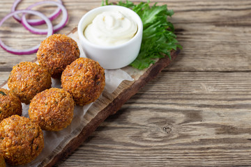 Vegetarian dish - falafel balls from spiced chickpeas on wooden rustic table.