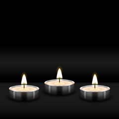 Obraz na płótnie Canvas Three tealight burning realistic candles on black background