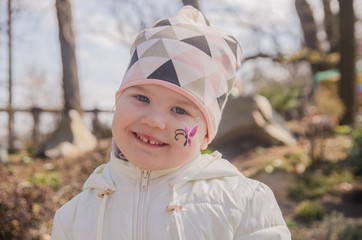Funny laughing curly girl with a butterfly on his nose. Healthy smile with white teeth. Free...