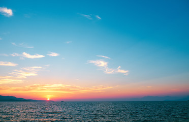 Naklejka premium beautiful sunset over the sea on a background of mountains