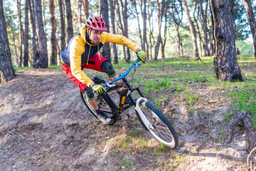 Cycling, a cyclist in bright clothes riding a mountain bike on the edge of a cliff. Active...